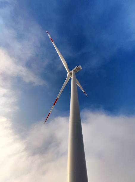 istock Vertical low angle shot of a wind turbine against a cloudy sky 1443191271