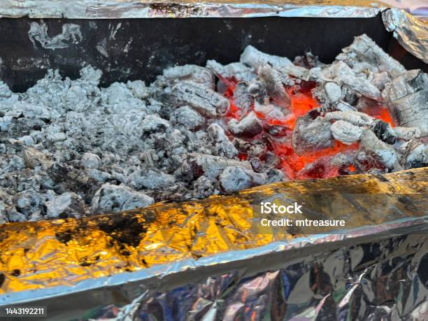 Closeup Image Of Metal Barbecue Tray Full Of Hot Charcoal Embers And Ash Flames Bring Coke Up To Heat For Cooking Elevated View Focus On Foreground Stock Photo - Download Image Now