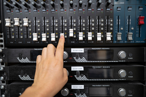 Hand is tuning mixer console buttons