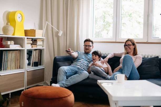 istock family watching television at home 1443194685