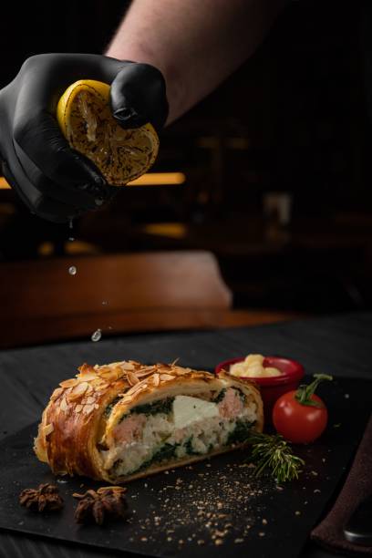 istock Human hand squeezing a lemon on French pie with salmon and cheese 1443196861