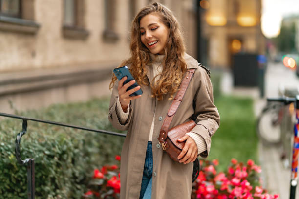 istock Young woman using mobile device standing in the city 1443197055