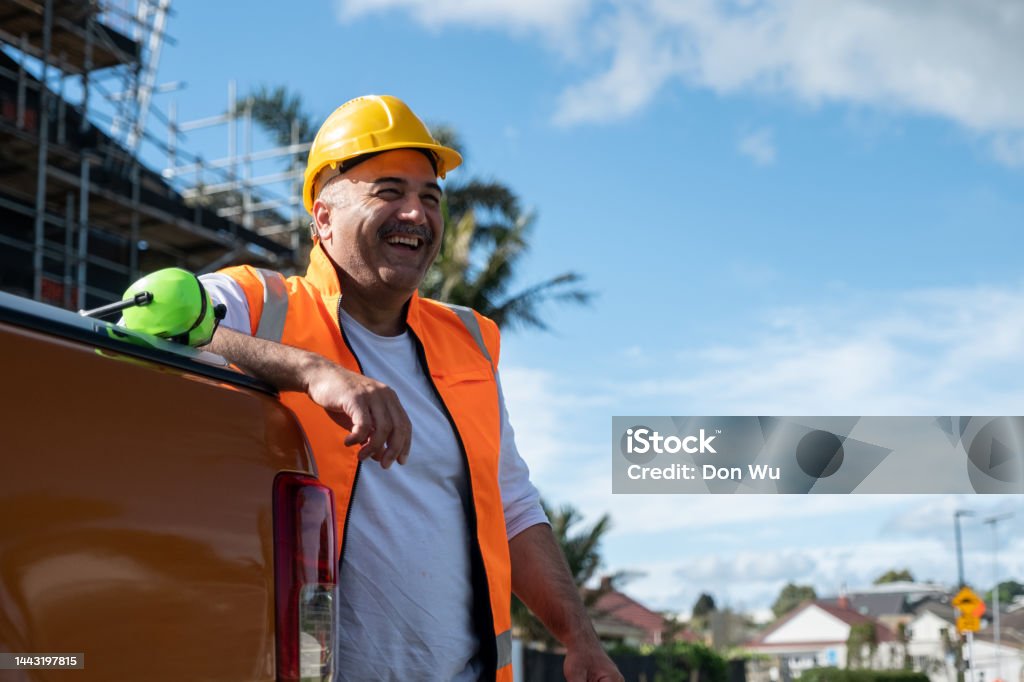 Happy Construction Worker A happy constuction work leaning against the back of a car Construction Worker Stock Photo