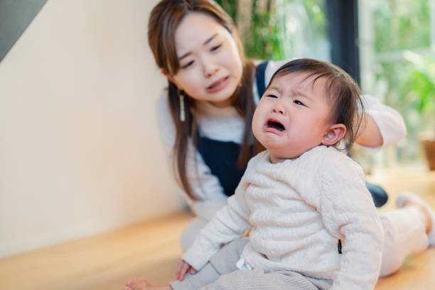 Babysitter nursing a crying baby stock photo