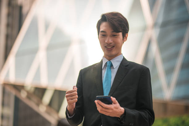 istock Happy Businessman Checking Phone Outdoors 1443203281