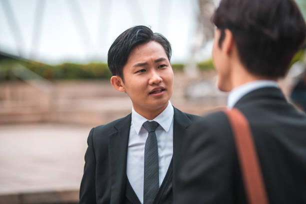 istock Over the Shoulder View of Asian Workers Talking 1443203291