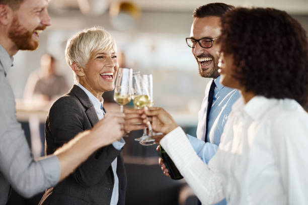 Toasting with champagne at office party! Happy business colleagues having fun while toasting with champagne on a party in the office. work party stock pictures, royalty-free photos & images