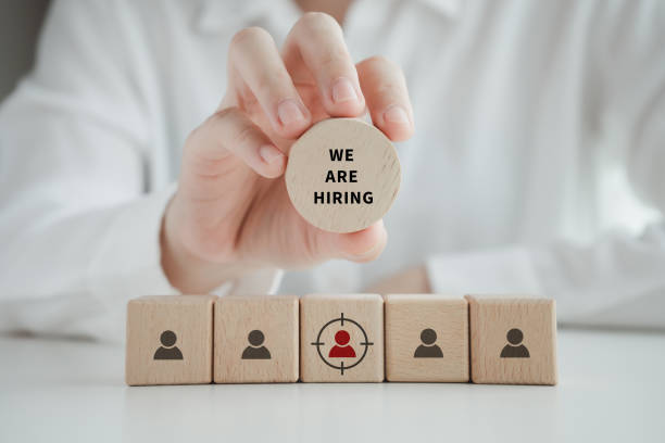 Human resources management and recruitment business hiring concept, Career opportunity, Job selection. Hand holding wooden circle with WE ARE HIRING word for finding new leader or employees to team. gestión de recursos humanos y concepto de contratación de empresas, oportunidad de carrera, selección de puestos. mano sosteniendo el círculo de madera con estamos contratando palabra para encontrar un nuevo líder o empleados para el equipo.
