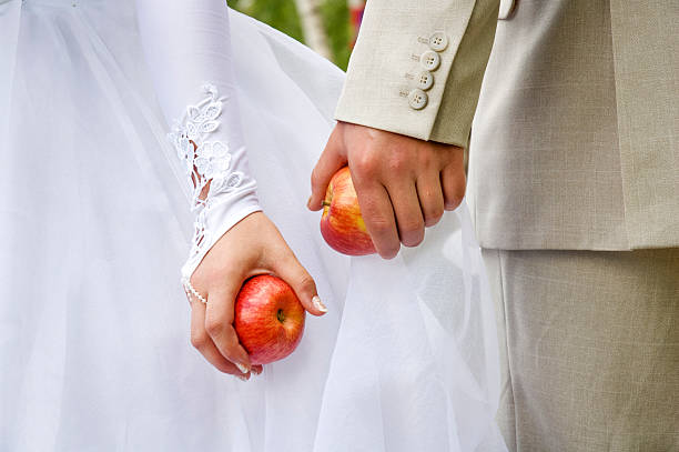 istock Bride and bridegroom hands with apples 144320930