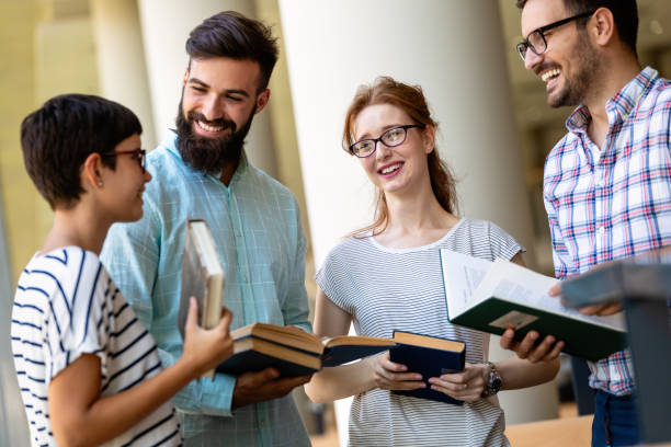 istock Students studying in library. Young success people are spending time together and learning together. 1443209616