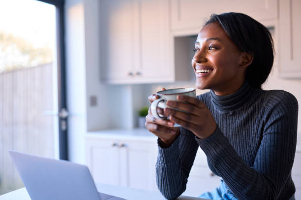 istock Young Woman At Home Working On Laptop On Counter In Kitchen 1443209945