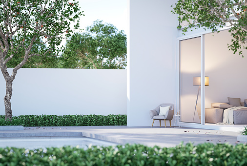 Minimalist modern white house exterior with swimming pool terrace 3d render Decorated with gray fabric furniture surrounded with green nature ,peaceful, comfortable, suitable for relaxation.