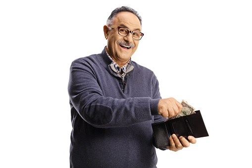 Cheerful mature man smiling and putting money in a wallet isolated on white background