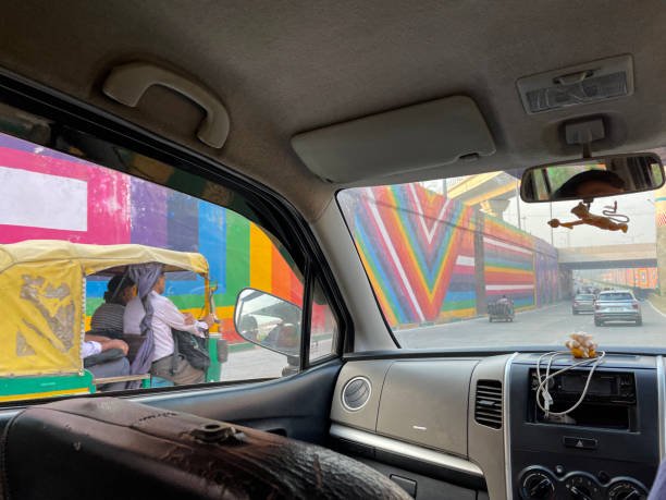 imagem do homem indiano dirigindo na rodovia / autoestrada em carro táxi privado, esperando o tráfego se mover, engarrafamento, riquixás de automóveis, tuk tuks amarelos e verdes, carros, motos, foco em primeiro plano - accident taxi driving tourist - fotografias e filmes do acervo