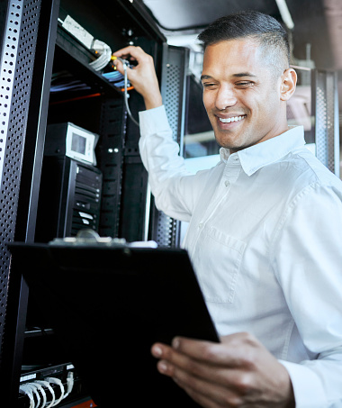Server room, IT support and database with a man programmer working on a mainframe in a data center. Software, cyber security and innovation with a male coder at work on a cloud for host networking
