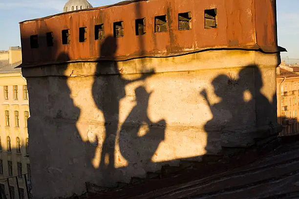 shadows of people playing the guitar on the Petersburg's roof