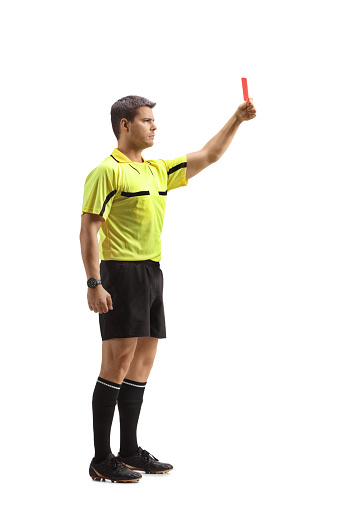 Full length profile shot of a football referee showing a red card isolated on white background