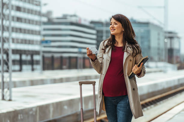 istock Woman holding a tickets on railroad station platform 1443217350