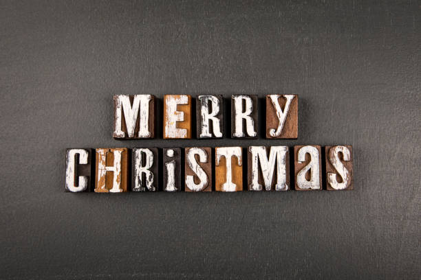 istock Merry Christmas concept. Alphabet wooden blocks on a dark board 1443218865