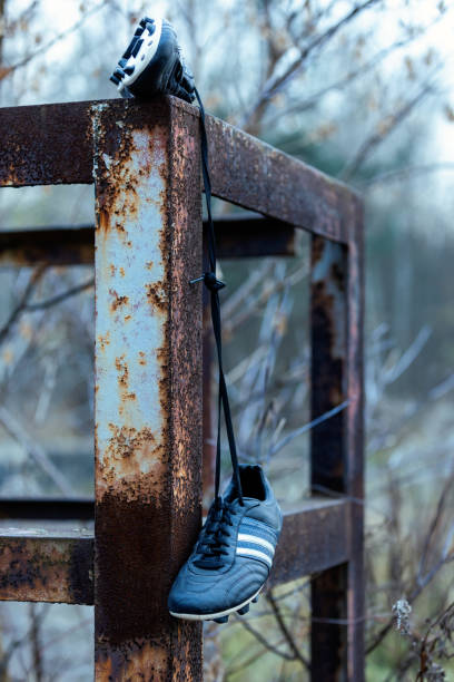 istock Soccer shoes hanging on metal construction. 1443218933