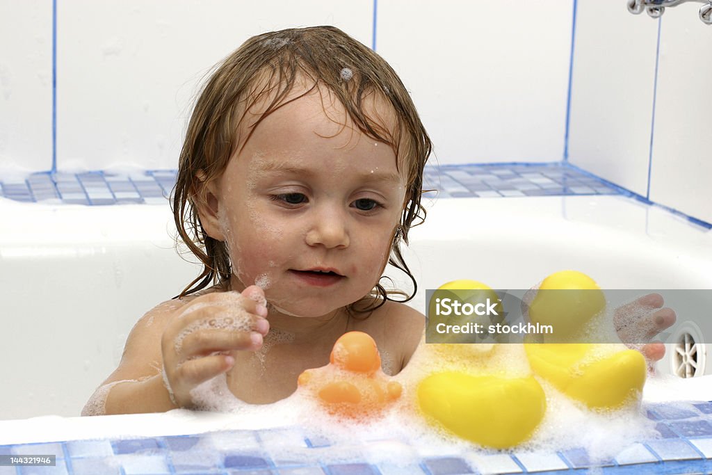 Baby in the bath Baby girl takes bath with three ducks Baby - Human Age Stock Photo