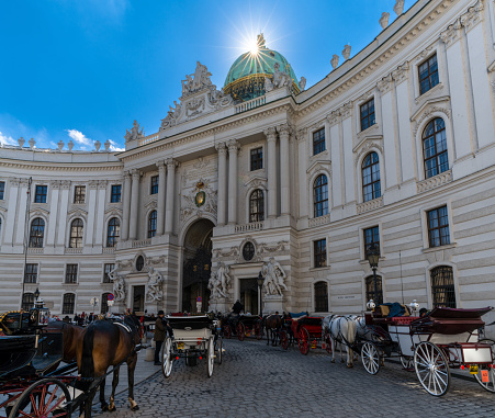 Vienna, Austria - 22 September, 2022: horse-drawn carriages outside of the historic Spanish Riding School building in Vienna