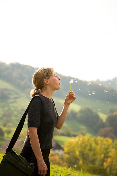 Woman blowing Dandelion