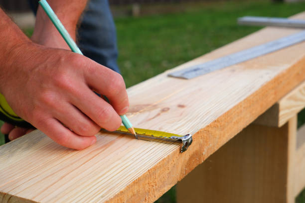 Male carpenter measuring wooden blank with the lines and making marks with a pencil and tape. Close up view. Male measuring wooden blank with the lines and making marks with a pencil and tape. handyman stock pictures, royalty-free photos & images