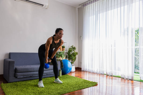 istock Woman using  dumbbell at home in living room. 1443222913