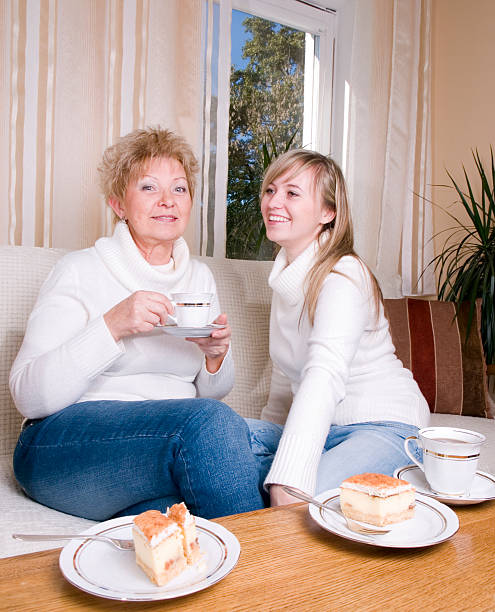 Mother and daughter drinking coffee together stock photo