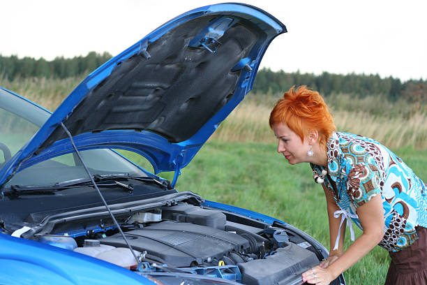 istock young red-haired woman with her broken car 144322303