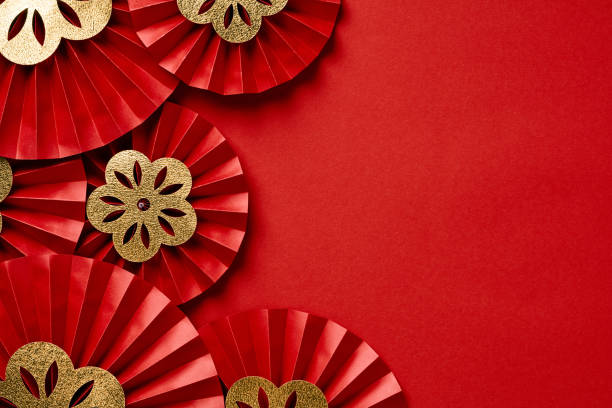 Chinese New Year festive paper fans with gold flowers on red background. stock photo