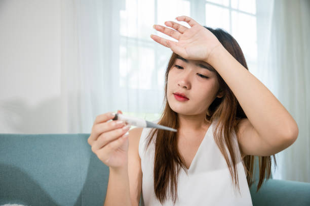 istock Sick woman have symptom sick high fever she checking her temperature with thermometer 1443223657