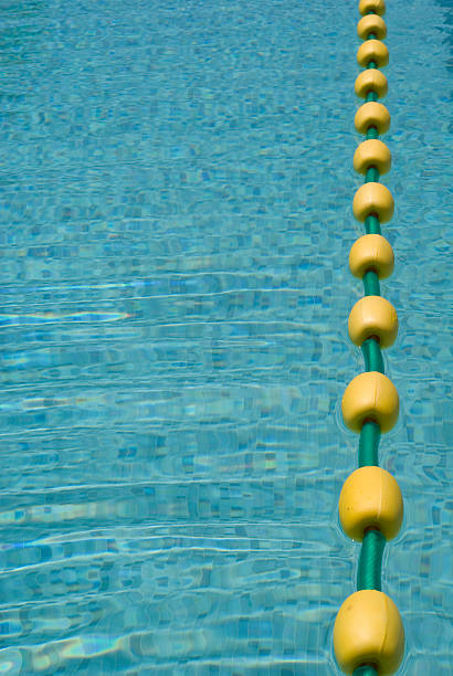 Swimming pool Close up of a pool with a line of yellow floats swimming pool lane ropes stock pictures, royalty-free photos & images