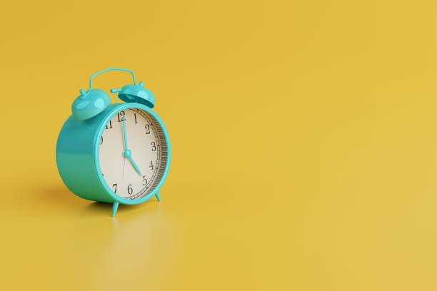 istock Turquoise retro alarm clock on yellow background. 1443226973