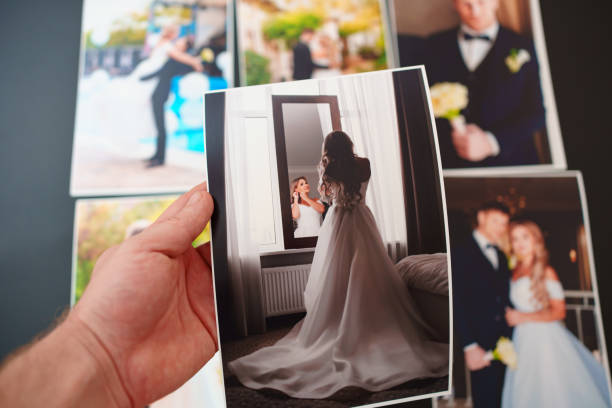 istock printed wedding photos on a black background and in hand. 1443227194