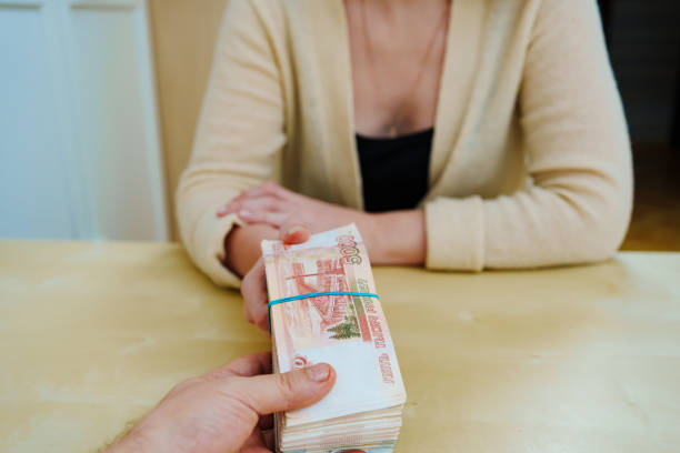 istock woman takes a stack of rubles tied with a rubber band. 1443228213