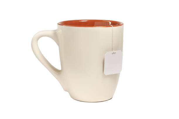 istock Beige ceramic mug with teabag label. for your design. isolated on white background 1443231006