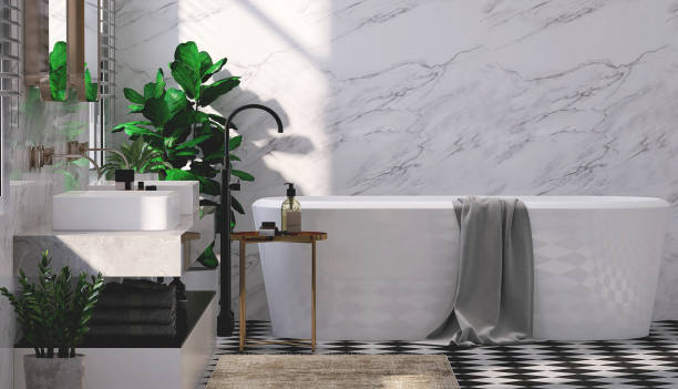 istock Modern and luxury design bathroom with bathtub, granite vanity, washbasin, side table and fiddle leaf fig tree in sunlight from window blinds on white marble wall and tile floor 1443232231