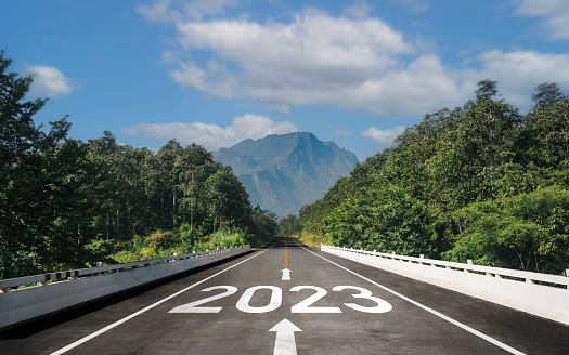 Text 2023 is written on the road and an arrow in the middle for the start of the new year from 2022 to 2023.Concept of planning and challenge, business strategy, opportunity, hope, vision
