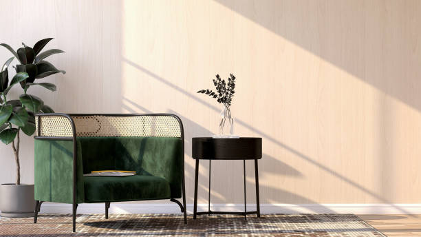 Classic, luxury barrel armchair with green cushion, rattan back, black side table with glass vase, fiddle leaf fig tree on carpet floor with sunlight on wooden wall stock photo