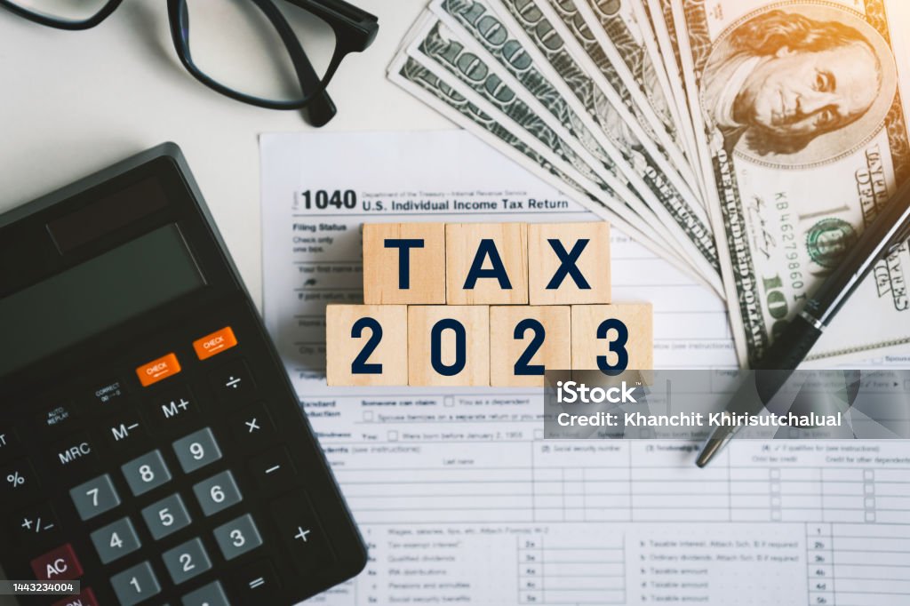 Tax text in wooden cubes and tax or vat form documents to complete Individual income tax return form for payment to Government. Calculation tax return in 2022 to 2023. Tax Stock Photo