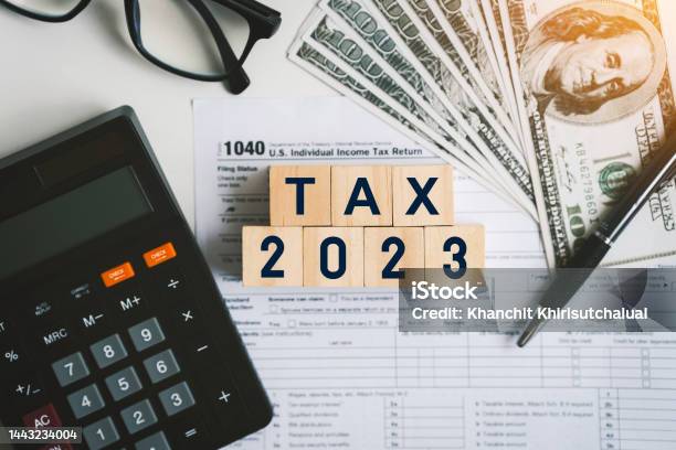 Tax Text In Wooden Cubes And Tax Or Vat Form Documents To Complete Individual Income Tax Return Form For Payment To Government Calculation Tax Return In 2022 To 2023 Stock Photo - Download Image Now