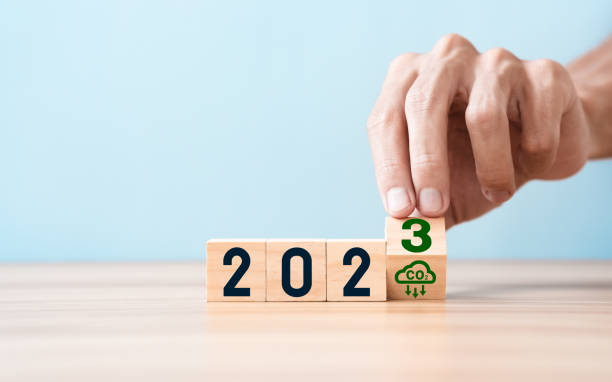 istock Hand puts wooden cubes with net zero icon in 2023 on blue sky background. in Net zero greenhouse gas emissions target and Carbon neutral in 2023 to 2050 Climate neutral long term strategy 1443234040
