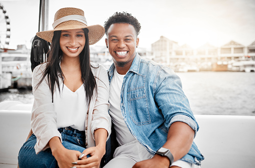 Couple, love and yacht with a man and woman on a date on the sea or ocean with the city, harbor or promenade in the background. Dating, romance and affection with a diverse male and woman outdoor