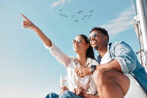 voyage en couple, boisson au champagne et rendez-vous sur le yacht, vin en vacances de mariage en grèce et heureux dans la célébration du mariage en vacances en croisière. l’homme et la femme se détendent avec un verre d’alcool sur le bateau - champagne flute champagne black wineglass photos et images de collection