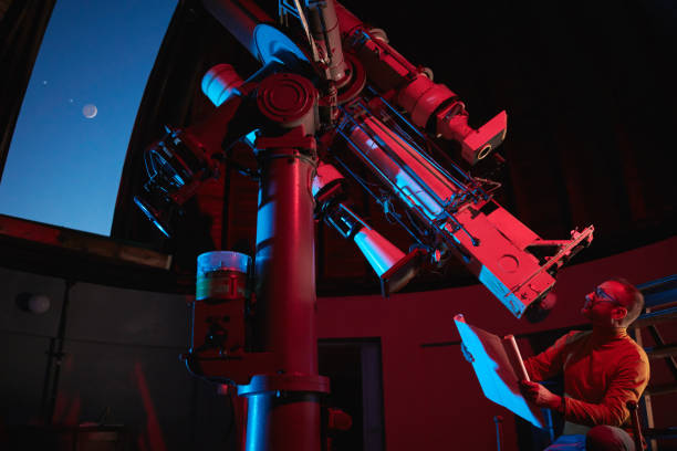 istock Astronomer with a big astronomical telescope in observatory doing science research. 1443234709