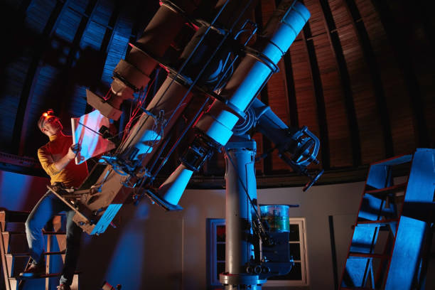 istock Astronomer with a big astronomical telescope in observatory doing science research. 1443235761