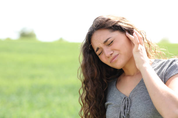 istock Woman suffering earache in a field 1443236198