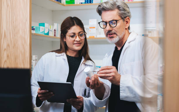 profissionais de saúde que preenchem prescrições on-line em uma farmácia - pharmacy medicine pharmacist storage room - fotografias e filmes do acervo